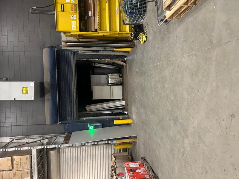 Commercial loading-bay roll-up door in open position inside warehouse workspace