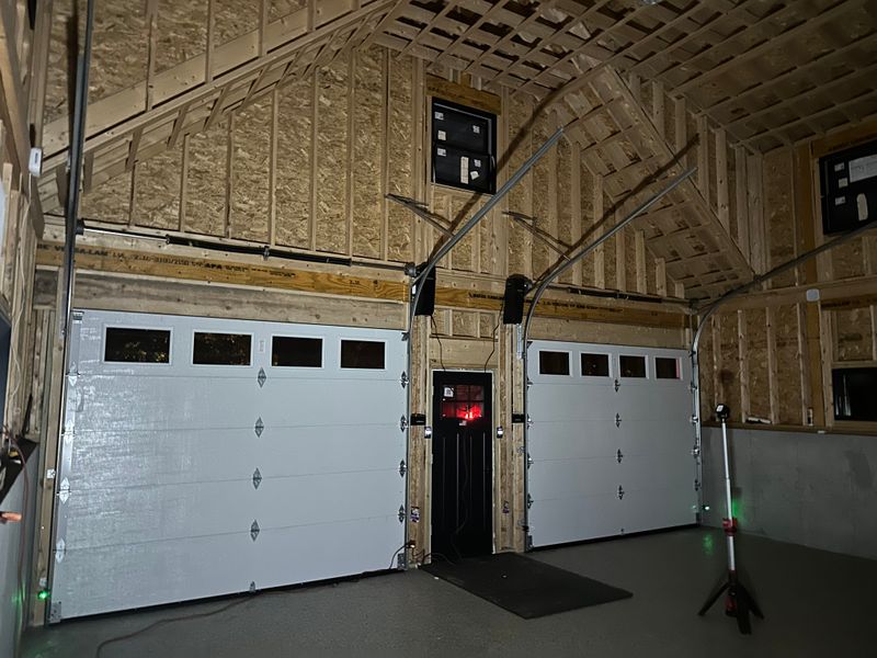 Interior view of new construction garage with dual white insulated doors and windows